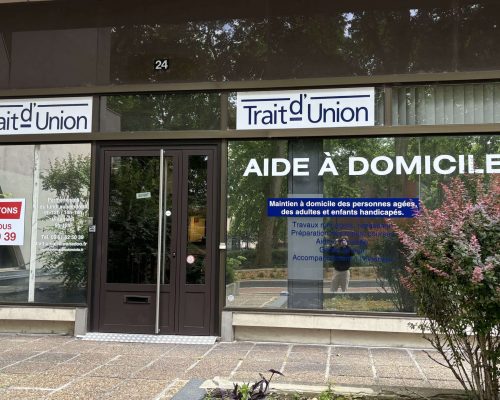 Façade du local Trait d’Union avec vitrine et informations de contact